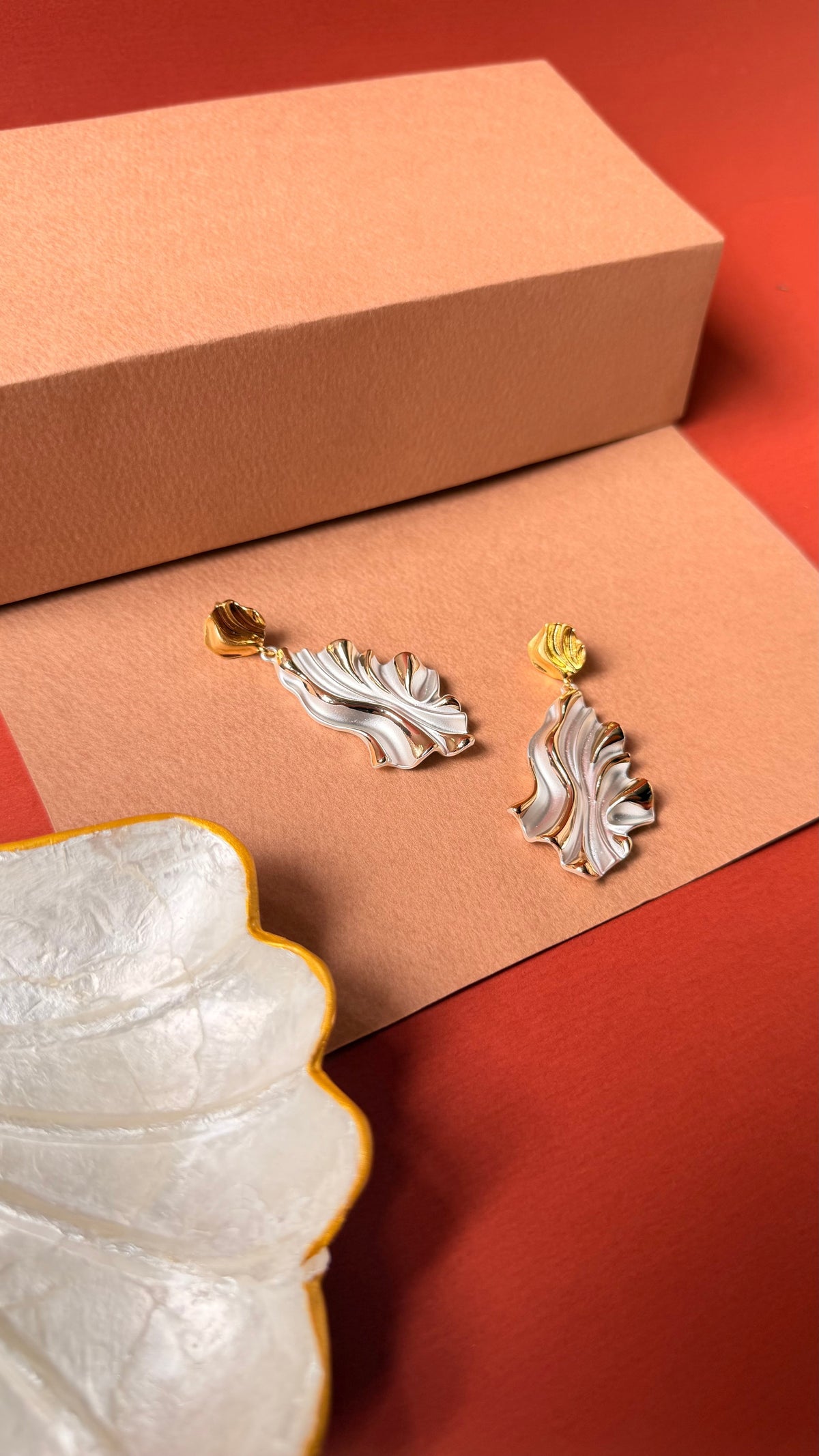 Daga-accessories two-tone metallic cascade earrings featuring a wavy leaf-like design in gold and silver finish.