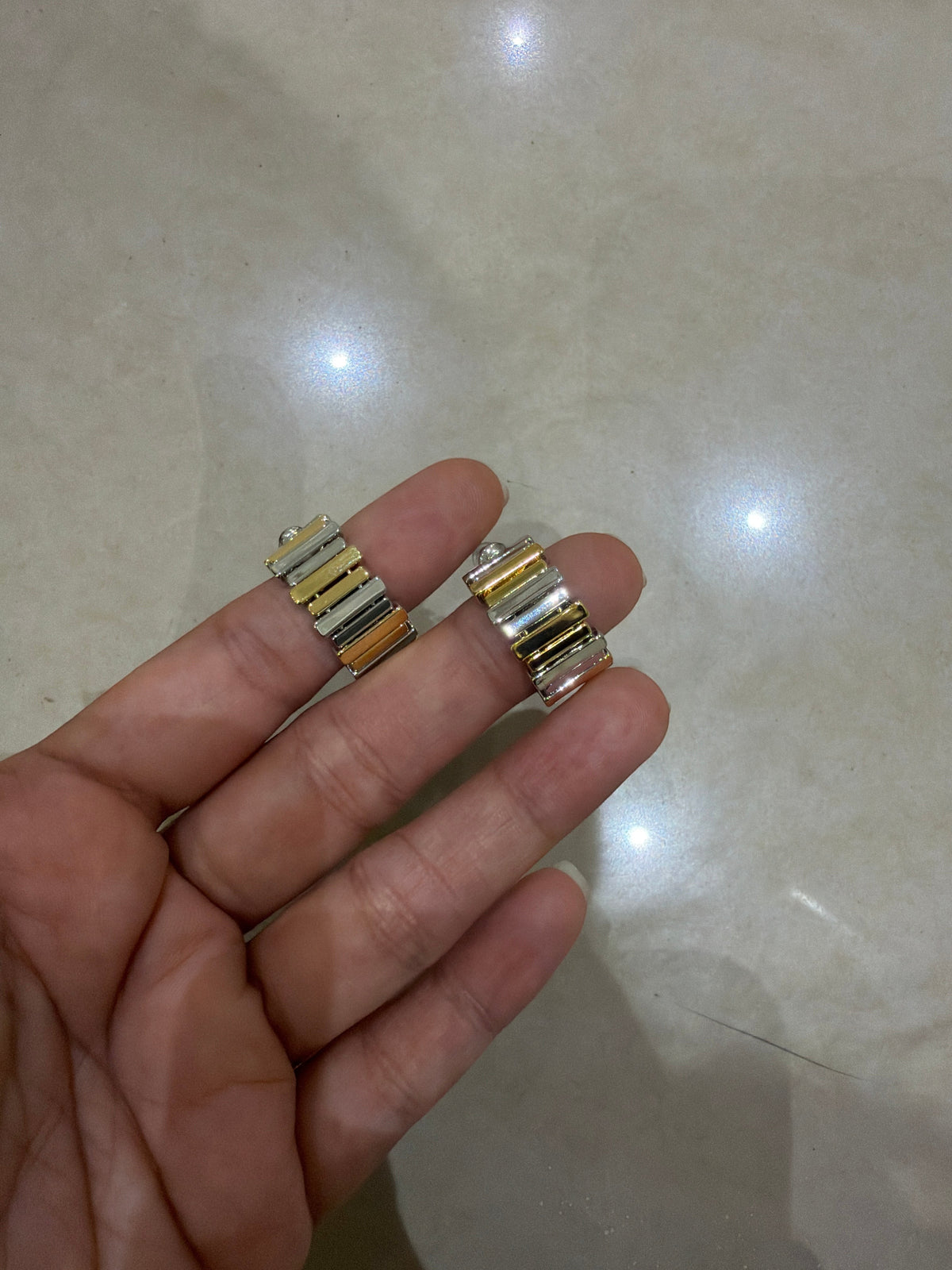 Daga-accessories two-toned hoop earrings featuring alternating matte silver and brushed gold textured segments.