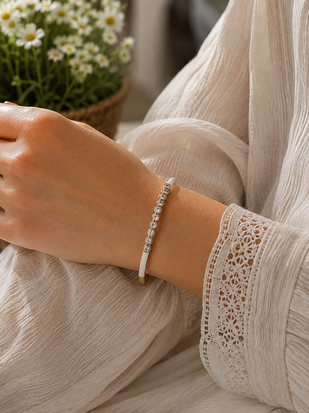 Daga-accessories white dotted crystal bracelet worn on a wrist with a white lace sleeve