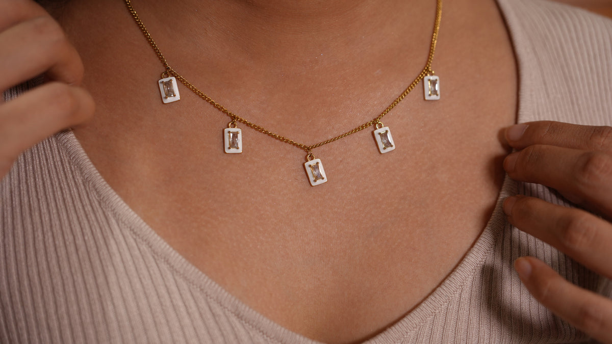 Daga-accessories white enamel rectangular charm necklace with clear stone accents on a gold stainless steel chain